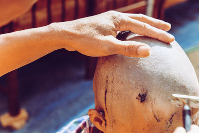 Close-up of man shaving head of boy