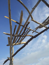 Low angle view of rusty metal fence against sky