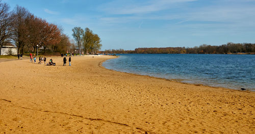 Wolfsburg, germany, march 14.,2020, yellow sandy beach at the blue allersee at  beginning of spring