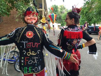 Portrait of happy friends standing against traditional clothing