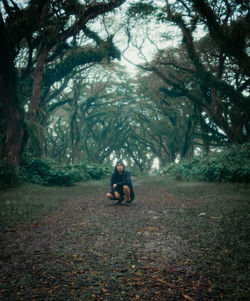 Rear view of woman sitting on field