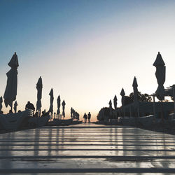 Group of people walking against sky during sunset