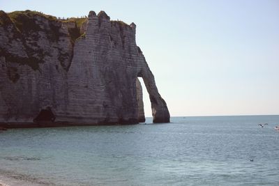 Rock formations in sea against sky
