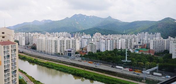 View of buildings in city against mountains 
