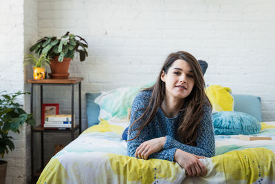 Young woman relaxing on bed in bedroom at home