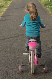 Full length rear view of woman riding bicycle