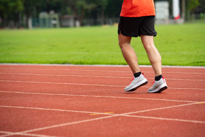 Low section of man jogging on running track