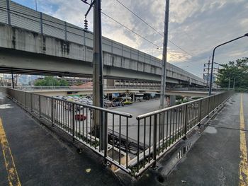 Bridge over street in city against sky