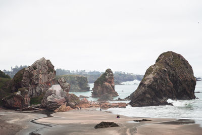 Rocks on beach against clear sky