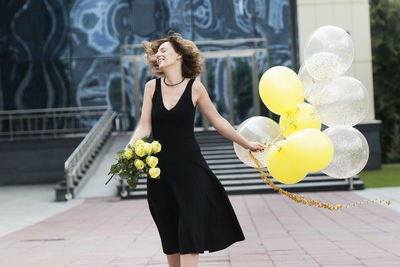 Cheerful mid adult woman goes to celebrate her birthday