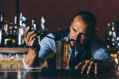 Bartender making drink at counter