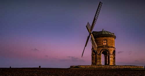 Low angle view of old castle on field against sky at sunset