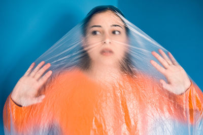 Portrait of woman against blue background