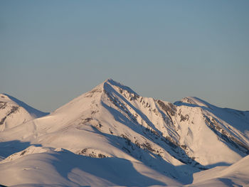 Scenic view of snowcapped mountains against clear sky