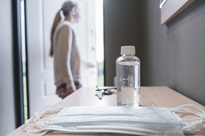 Side view of woman standing on table at home