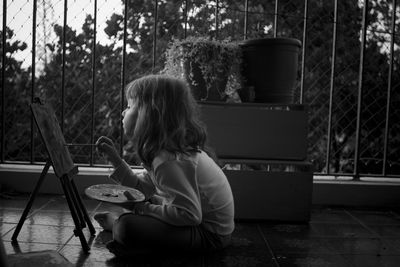 Girl painting on canvas in balcony