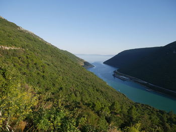 Scenic view of sea and mountains against clear sky