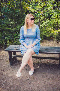 Young woman sitting on bench in park