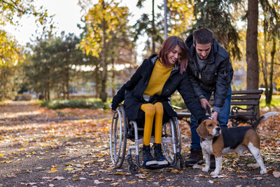 Man with dog standing in park during autumn