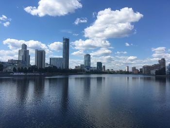 Scenic view of river by buildings against sky