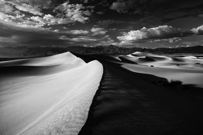 Scenic view of mesquite flat sand dunes against cloudy sky