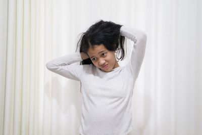 Portrait of boy standing against wall at home