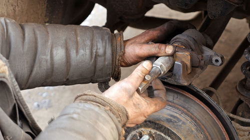 Cropped image of male mechanic repairing car