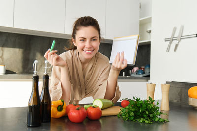 Portrait of young woman preparing food at home