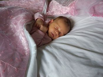 Close-up of baby sleeping in bed