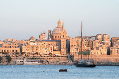 Boats in sea against buildings in old city