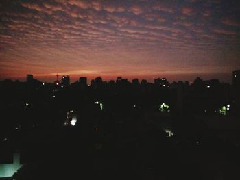 Illuminated cityscape against sky at night