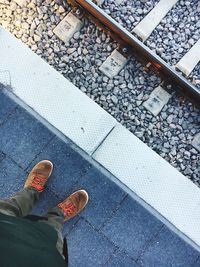 Low section of man standing on railroad station platform