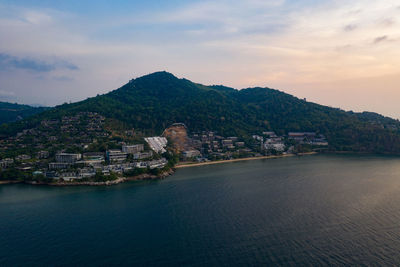 Aerial view of townscape by sea against sky