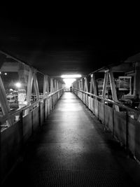 Illuminated lights on empty footpath at night