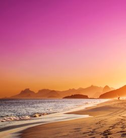 Scenic view of beach against clear sky during sunset