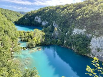 High angle view of lake amidst trees against sky