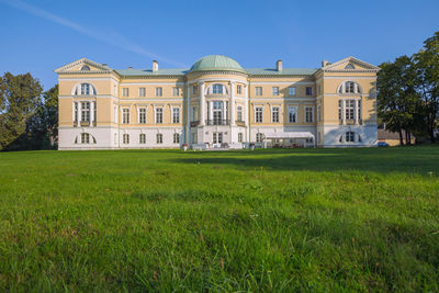 Lawn by building against clear sky