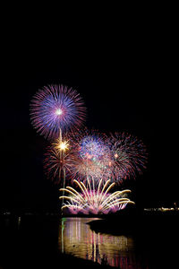 Low angle view of illuminated fireworks against sky at night