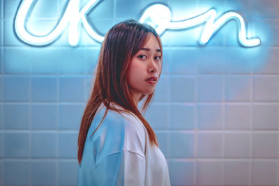Portrait of beautiful woman standing against wall