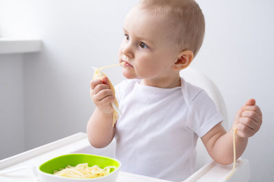 Portrait of boy eating food at home