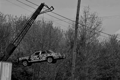 Crane lifting abandoned car at junkyard