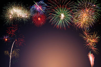 Low angle view of firework display at night