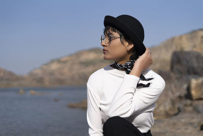 Young woman wearing hat looking away outdoors