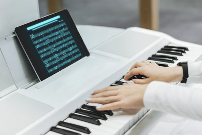 Midsection of man playing piano