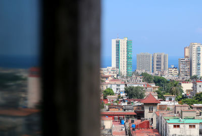 Buildings in city against clear blue sky