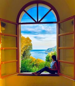 Rear view of man sitting by window