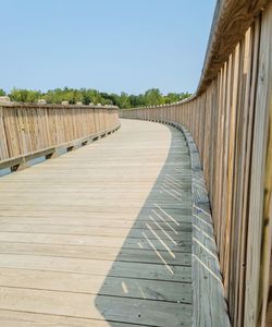 Surface level of boardwalk on footpath against clear sky