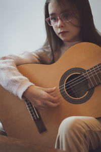 Little girl plays the guitar.