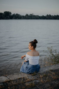 Woman sitting by lake