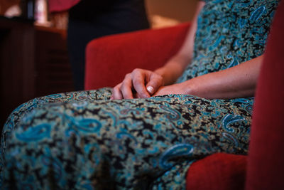 Midsection of woman sitting on chair